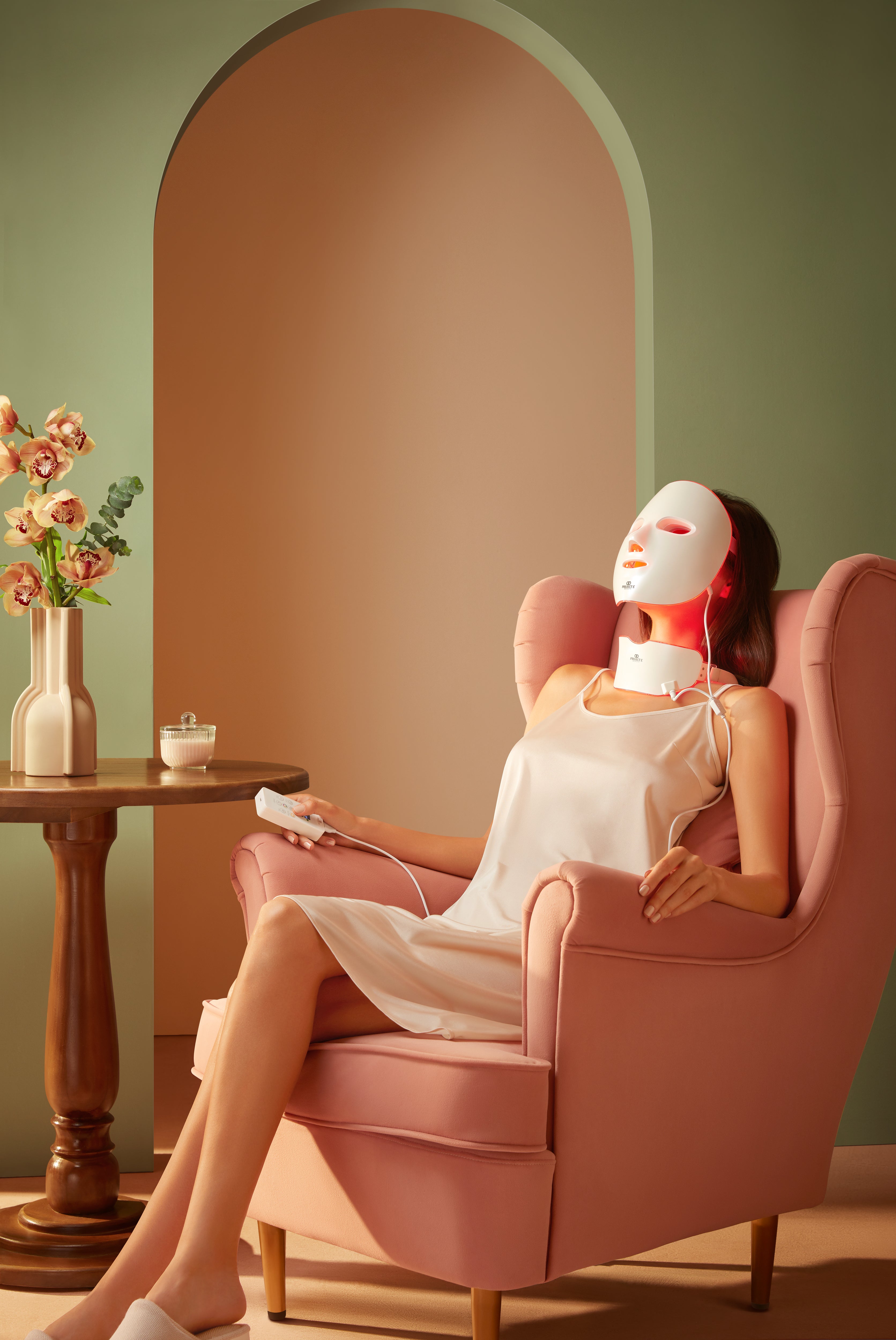Red light therapy device in use by woman during at-home facial